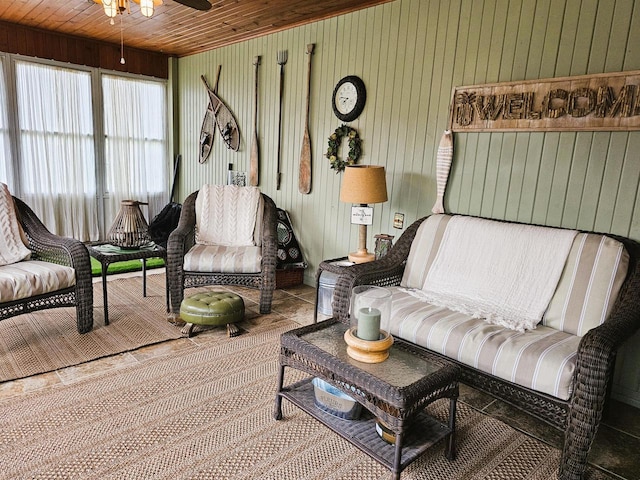 living room with wood ceiling, a ceiling fan, and wood walls