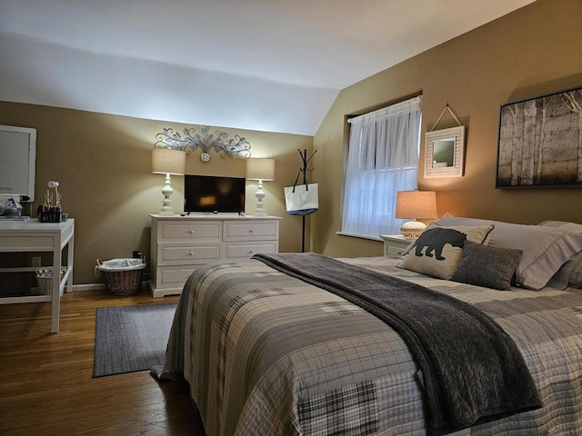 bedroom featuring baseboards, lofted ceiling, and wood finished floors