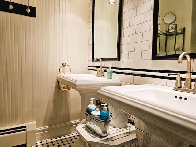 bathroom featuring a sink, tasteful backsplash, and a baseboard heating unit