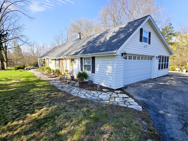 view of side of property featuring a shingled roof, a yard, and driveway