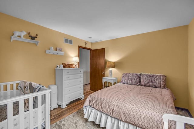 bedroom with wood finished floors and visible vents