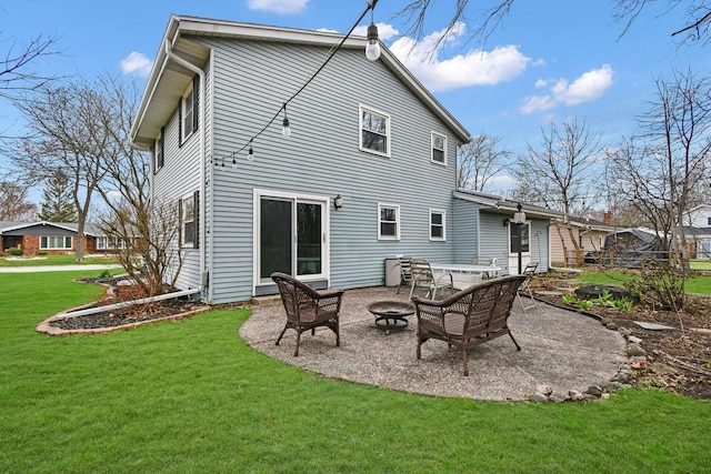 back of property with a yard, a fire pit, and a patio area