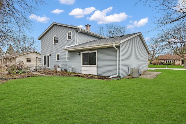 back of house featuring a lawn, roof with shingles, a chimney, and cooling unit