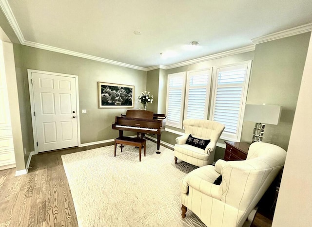 sitting room featuring baseboards, ornamental molding, and wood finished floors