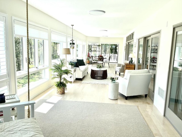 sunroom / solarium with visible vents and wood finished floors