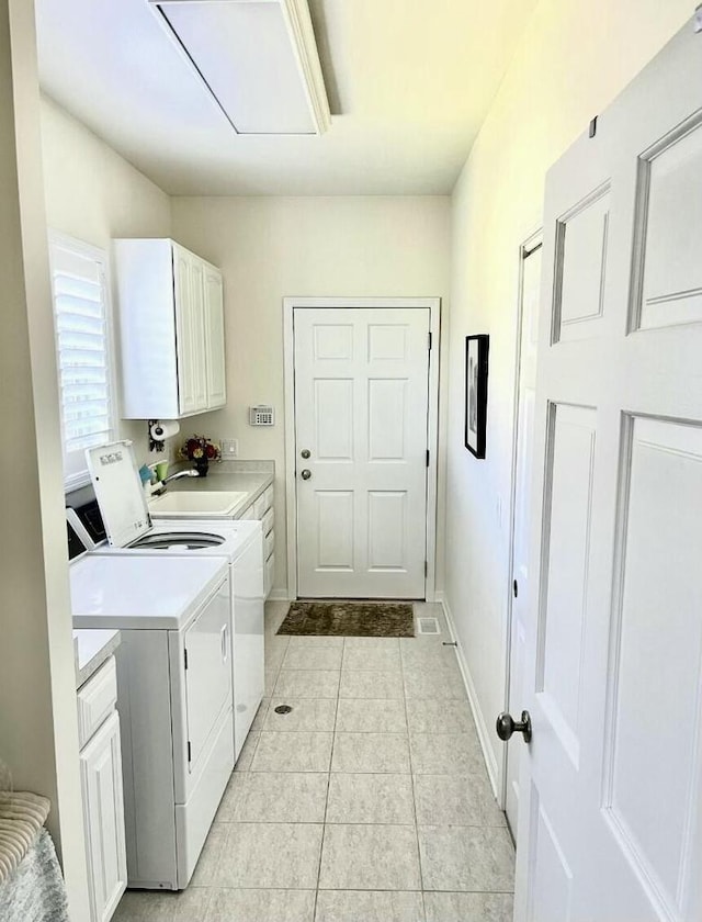 laundry room featuring attic access, washing machine and dryer, cabinet space, light tile patterned floors, and a sink
