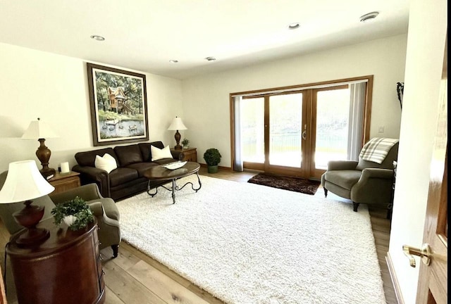 living room featuring french doors, recessed lighting, and light wood-type flooring