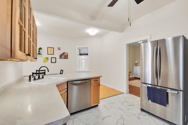 kitchen featuring a sink, marble finish floor, light countertops, a ceiling fan, and appliances with stainless steel finishes