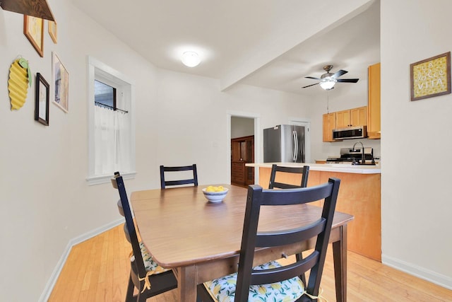 dining room with light wood-style floors, baseboards, and ceiling fan