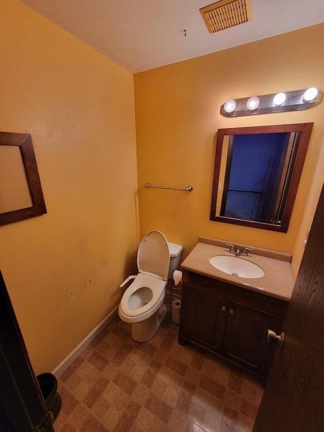 half bath with toilet, visible vents, and vanity