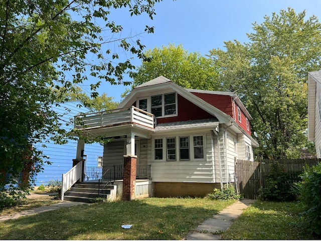 4566 N 28th St, Milwaukee, WI 53209 - bungalow with fence, covered porch, a front lawn, and a balcony
