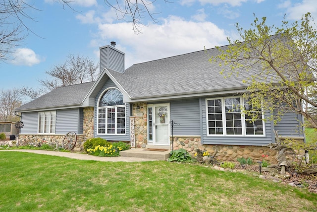 view of front of home featuring a chimney, a shingled roof, stone siding, and a front lawn
