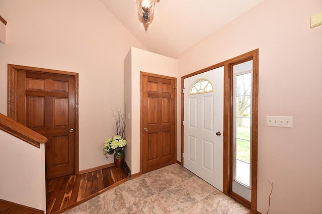 entrance foyer featuring a healthy amount of sunlight, baseboards, and lofted ceiling