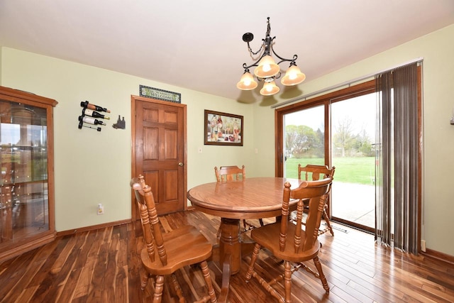 dining space featuring baseboards, wood-type flooring, and a notable chandelier