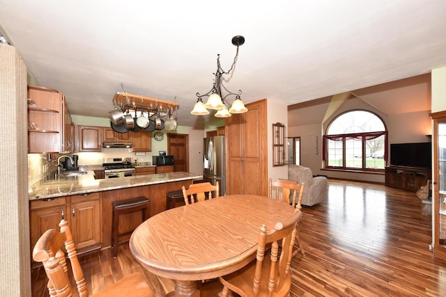 dining space with wood finished floors and a notable chandelier