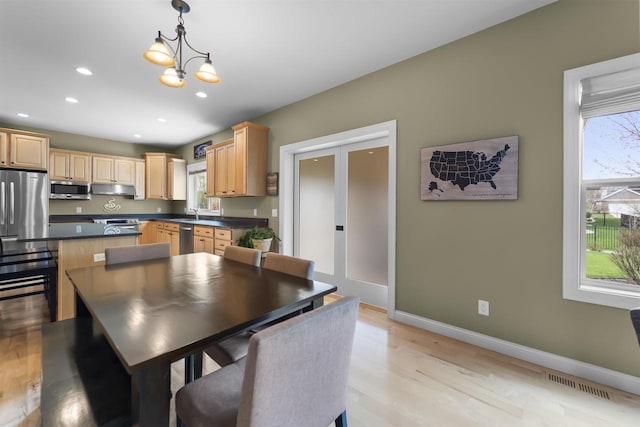 kitchen featuring dark countertops, appliances with stainless steel finishes, a healthy amount of sunlight, and visible vents