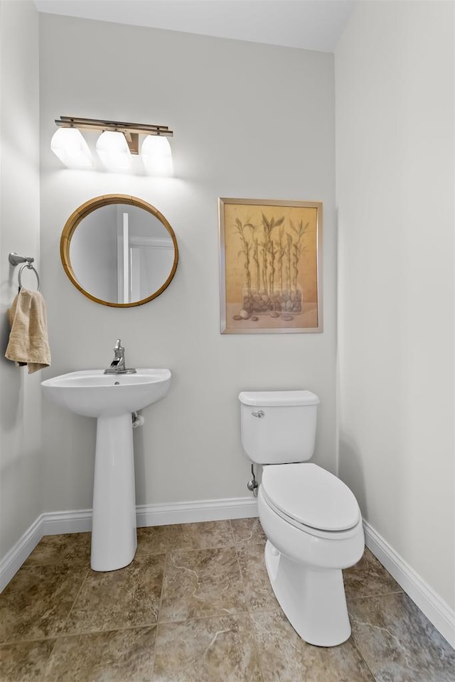 bathroom featuring baseboards and toilet