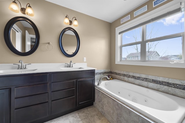 bathroom with double vanity, visible vents, a tub with jets, and a sink