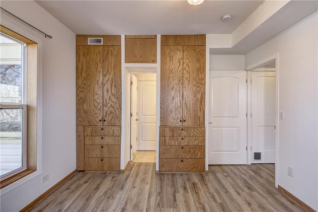 603 Dodge St, Eau Claire, WI 54701 - unfurnished bedroom with baseboards, light wood finished floors, and visible vents