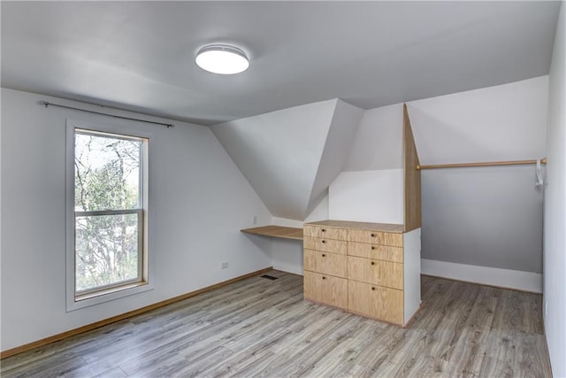 603 Dodge St, Eau Claire, WI 54701 - bonus room featuring baseboards, light wood-style flooring, and lofted ceiling