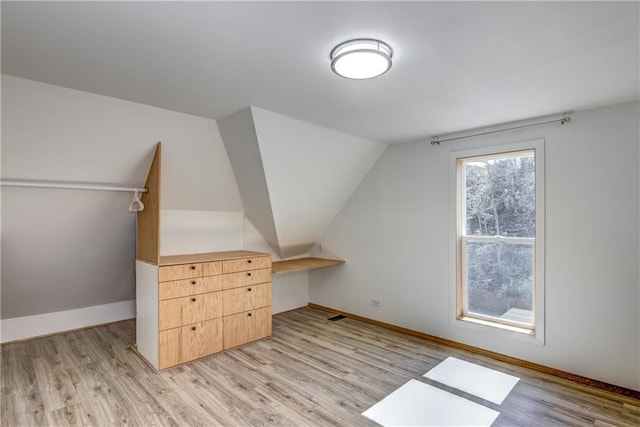 603 Dodge St, Eau Claire, WI 54701 - bonus room featuring baseboards, vaulted ceiling, and light wood finished floors