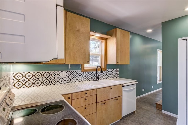 603 Dodge St, Eau Claire, WI 54701 - kitchen with light brown cabinetry, white dishwasher, a sink, and tasteful backsplash