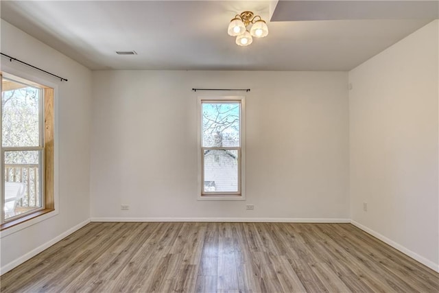 603 Dodge St, Eau Claire, WI 54701 - empty room featuring baseboards, wood finished floors, and visible vents