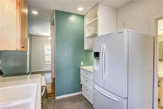 603 Dodge St, Eau Claire, WI 54701 - kitchen with open shelves, baseboards, recessed lighting, light countertops, and white fridge with ice dispenser