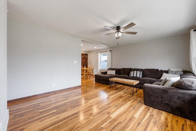 living area featuring a ceiling fan, baseboards, recessed lighting, and light wood-style floors