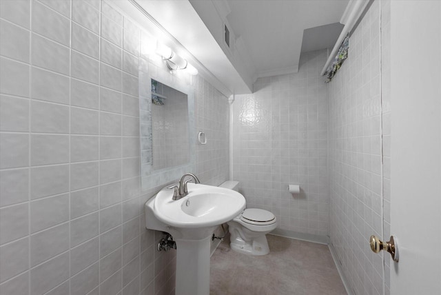 half bath featuring tile walls, toilet, and visible vents