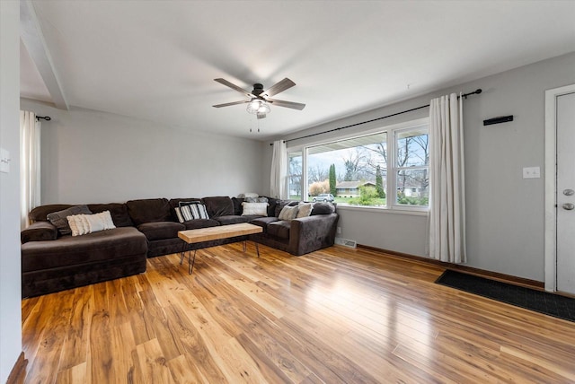 living room with ceiling fan and light wood finished floors