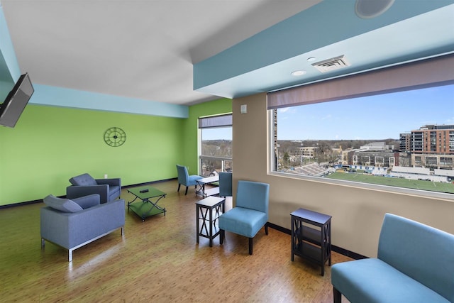 sitting room featuring baseboards, visible vents, and wood finished floors