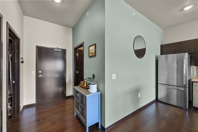 kitchen featuring light countertops, appliances with stainless steel finishes, dark brown cabinetry, and dark wood-style floors