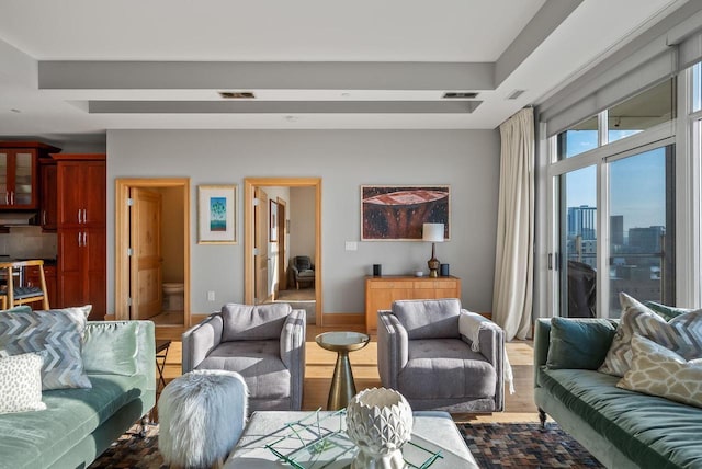 living room featuring visible vents, a view of city, and wood finished floors