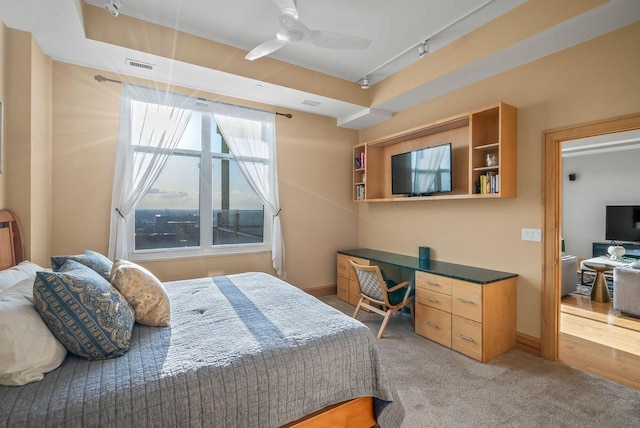 carpeted bedroom with track lighting, baseboards, and visible vents