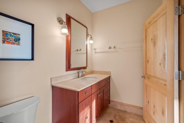 bathroom featuring vanity, baseboards, and toilet