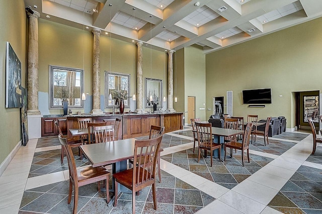 dining space with visible vents, a towering ceiling, beam ceiling, baseboards, and ornate columns