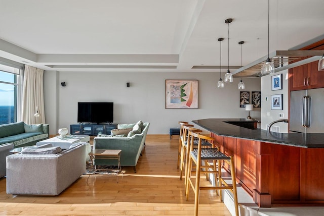 living room featuring light wood finished floors and bar area