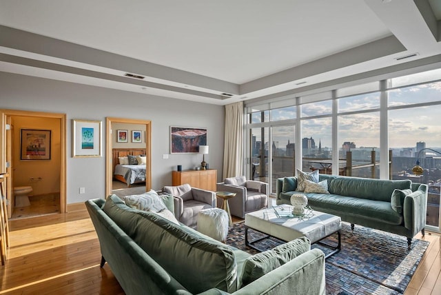 living area featuring visible vents, a city view, and hardwood / wood-style floors