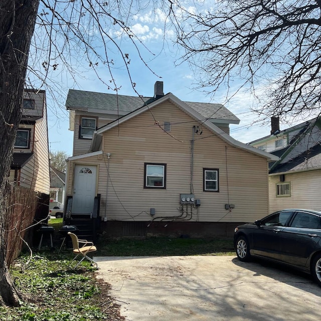 1312 Center St, Racine, WI 53403 - rear view of property featuring entry steps, fence, and a chimney