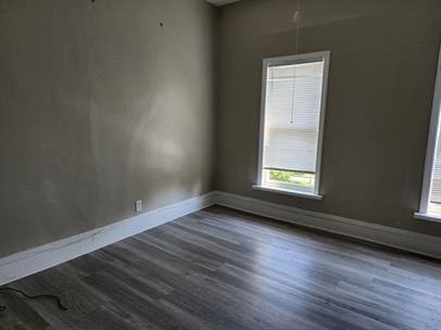 1312 Center St, Racine, WI 53403 - unfurnished room featuring baseboards, dark wood finished floors, and a healthy amount of sunlight