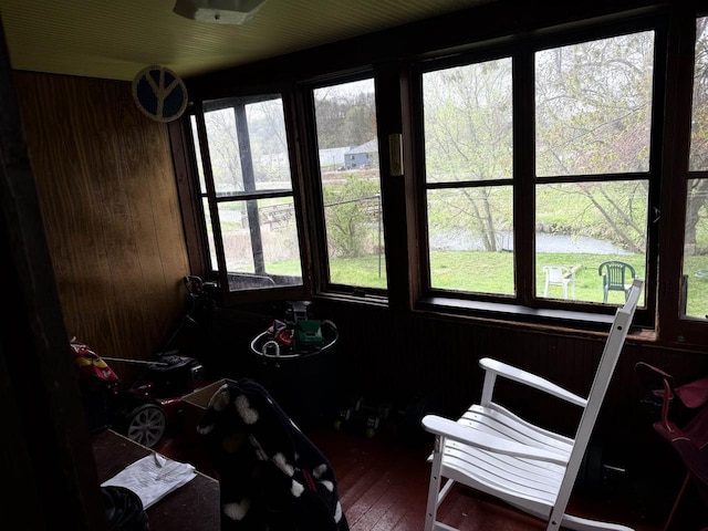 sunroom / solarium featuring a water view