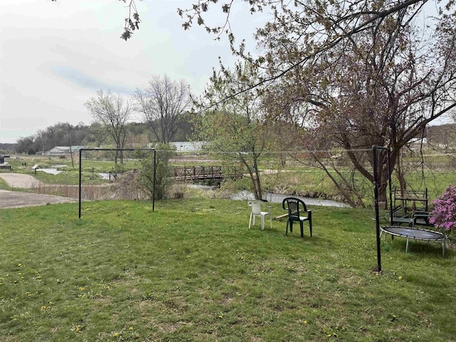 view of community with a yard and a trampoline