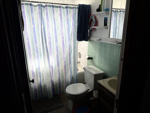 bathroom featuring tile walls, shower / tub combo, tile patterned floors, vanity, and toilet