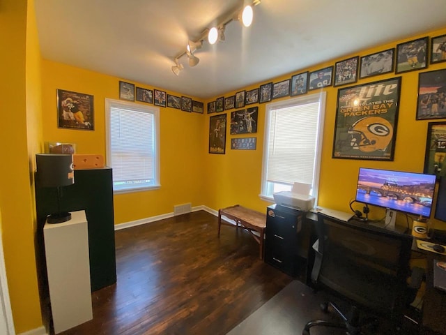 office with baseboards, visible vents, a healthy amount of sunlight, and dark wood-type flooring