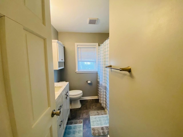 bathroom featuring toilet, baseboards, visible vents, and vanity