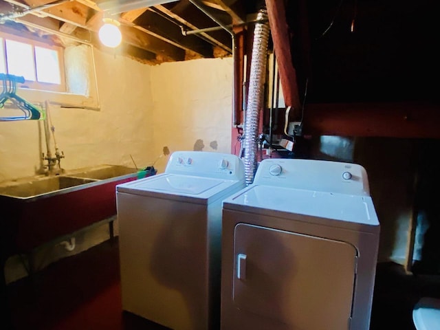 washroom featuring a sink, laundry area, and washer and dryer