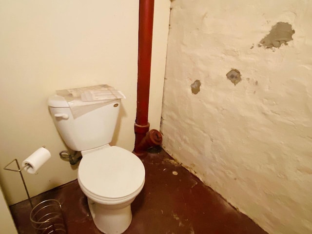 bathroom with toilet and concrete flooring