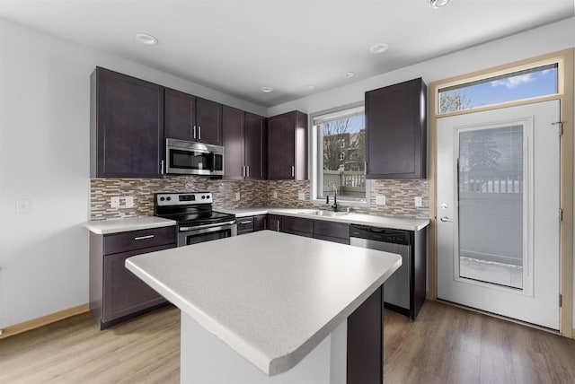 kitchen featuring a sink, light countertops, tasteful backsplash, and stainless steel appliances
