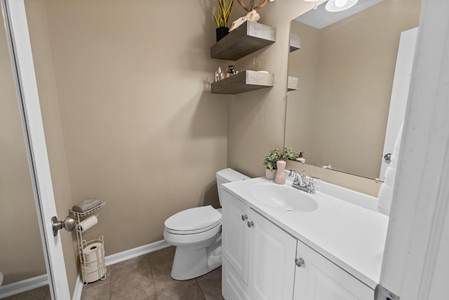 bathroom with vanity, baseboards, tile patterned flooring, and toilet